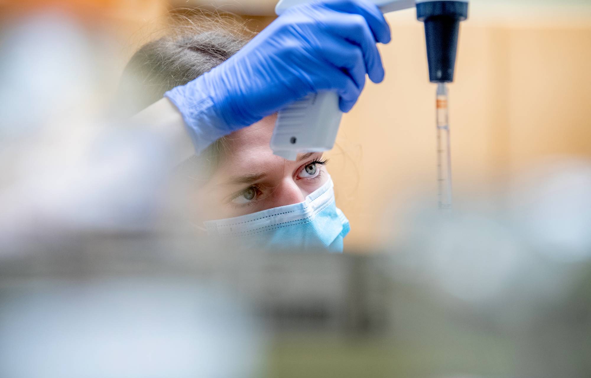 girl with face mask and gloves handling biology equipment